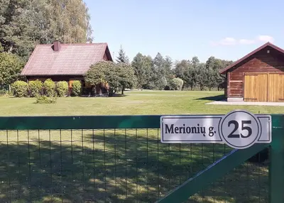 a sign on a fence in front of a house at Vila Mera in Pabradė