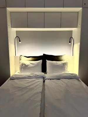 a white bed with two pillows on top of it at Parko rezidencija apartments - SELF CHECK-IN in Panevėžys