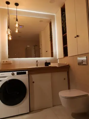 a bathroom with a washing machine and a mirror at Parko rezidencija apartments - SELF CHECK-IN in Panevėžys