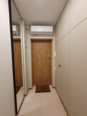 a hallway with a wooden door and a mirror at Parko rezidencija apartments - SELF CHECK-IN in Panevėžys