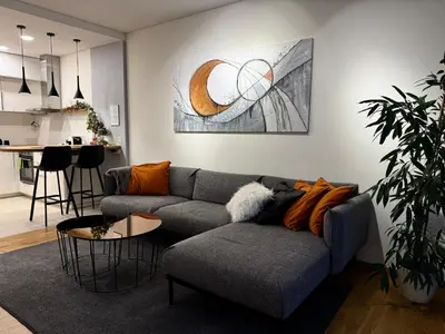 a living room with a gray couch and a table at Parko rezidencija apartments - SELF CHECK-IN in Panevėžys