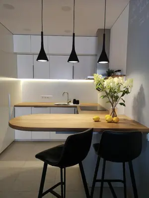 a kitchen with a wooden table and two chairs at Parko rezidencija apartments - SELF CHECK-IN in Panevėžys
