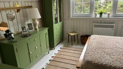 a bedroom with green cabinets and a bed and a window at Sodyba ramiam poilsiui in Kaltanėnai