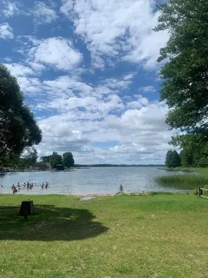 a group of people swimming in a body of water at Sodyba ramiam poilsiui in Kaltanėnai