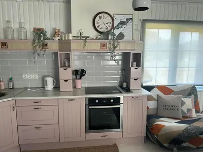a kitchen with white cabinets and a stove top oven at Sodyba ramiam poilsiui in Kaltanėnai