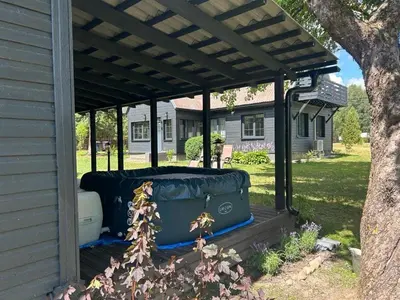 a pergola with suitcases sitting under a house at Sodyba ramiam poilsiui in Kaltanėnai