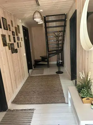 a hallway of a house with a staircase and a rug at Sodyba ramiam poilsiui in Kaltanėnai