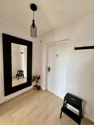 a room with a mirror and a chair in it at Rokiskis- jaukus butas su balkonu in Rokiškis