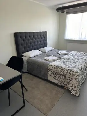 a bedroom with a large bed and a table at VESK Veisiejai in Veisiejai