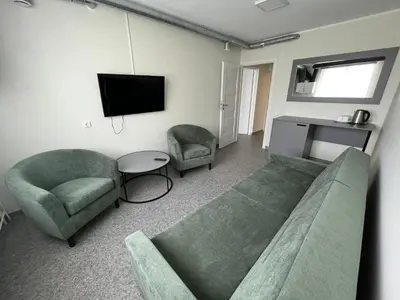 a living room with a couch and chairs and a tv at VESK Veisiejai in Veisiejai