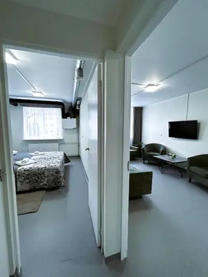 a hotel room with a bed and a living room at VESK Veisiejai in Veisiejai