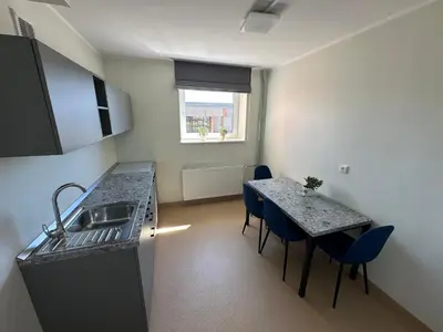 a kitchen with a sink and a table with chairs at VESK Veisiejai in Veisiejai