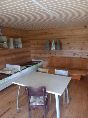 a room with a table and chairs in a cabin at Poilsis Dumblio telmologiniame draustinyje in Molėtai