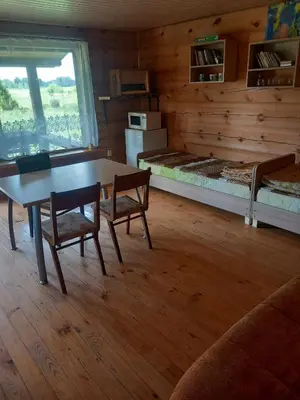 a room with a table and chairs and a bed at Poilsis Dumblio telmologiniame draustinyje in Molėtai