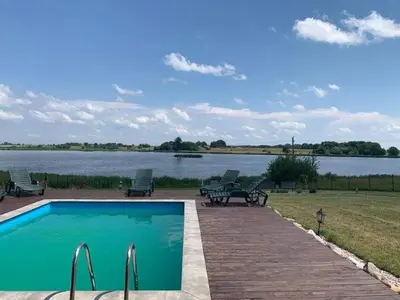 a swimming pool with a view of a lake at Pirties namelis in Girininkai