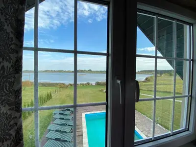 a window with a view of a body of water at Pirties namelis in Girininkai