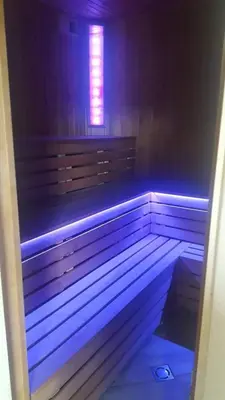 a bench with a blue light in a room at Pirties namelis in Girininkai
