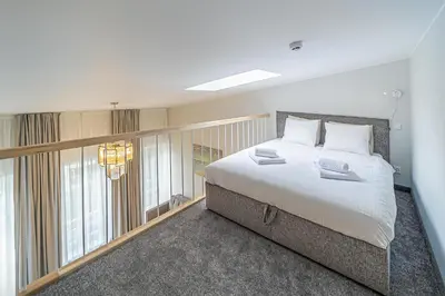 a bedroom with a large bed and a large window at Modern Loft Apartment with free parking No 1 in Marijampolė