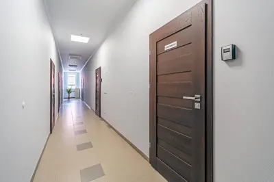 a hallway with a brown door and a hallwayngth at Modern Loft Apartment with free parking No 1 in Marijampolė