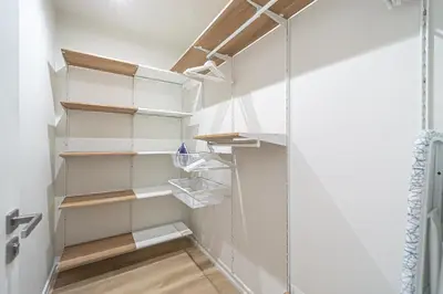 a walk in closet with white shelves at Modern Loft Apartment with free parking No 1 in Marijampolė