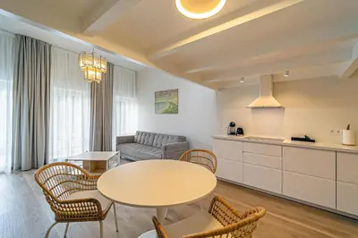 a kitchen and a living room with a table and chairs at Modern Loft Apartment with free parking No 1 in Marijampolė