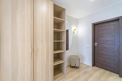 a closet with wooden cabinets and a door in a room at Modern Loft Apartment with free parking No 1 in Marijampolė