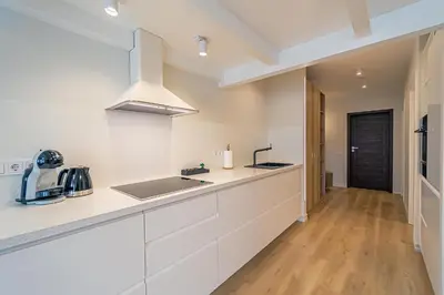 a kitchen with white cabinets and a counter top at Modern Loft Apartment with free parking No 1 in Marijampolė