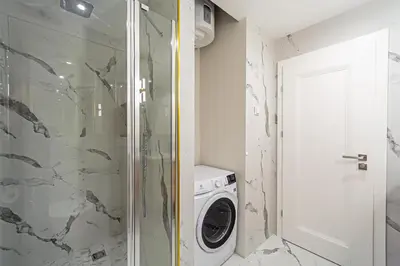 a bathroom with a washing machine and a washer at Modern Loft Apartment with free parking No 1 in Marijampolė