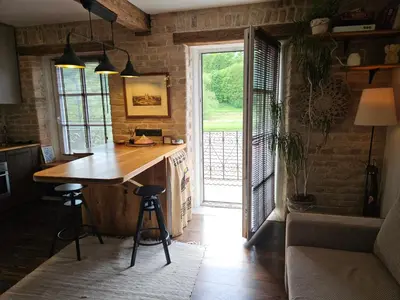 a kitchen with a wooden counter and a large window at Paupio Gertruda in Vilnius