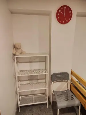 a teddy bear sitting on a shelf next to a clock at Comfort Akacija Hotel in Vilnius