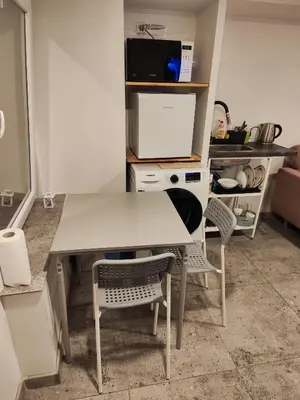 a kitchen with a white table and two chairs at Comfort Akacija Hotel in Vilnius