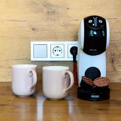 a coffee maker and two cups on a table at Karaliaus apartment in Kaunas