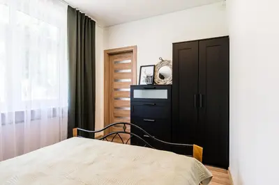 a bedroom with a bed and a black cabinet at Karaliaus apartment in Kaunas
