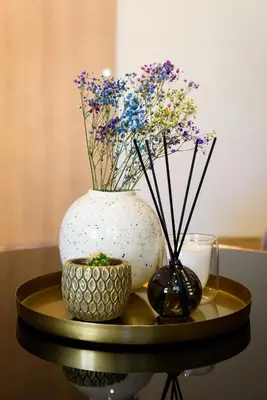 a table with a vase and a bowl with flowers at Karaliaus apartment in Kaunas