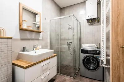 a bathroom with a sink and a washing machine at Karaliaus apartment in Kaunas