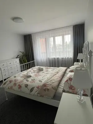 a bedroom with a bed with a floral bedspread at ROTUŠĖS g 23 APARTMENTS IN THE CITY CENTER BIRŽAI in Biržai