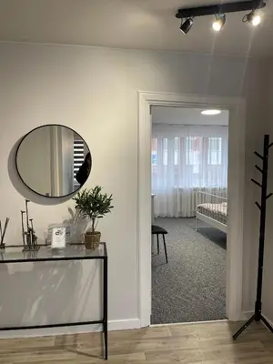 a room with a mirror on the wall and a table at ROTUŠĖS g 23 APARTMENTS IN THE CITY CENTER BIRŽAI in Biržai