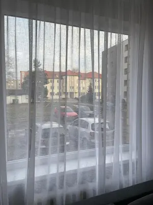 a window with a view of a parking lot at ROTUŠĖS g 23 APARTMENTS IN THE CITY CENTER BIRŽAI in Biržai