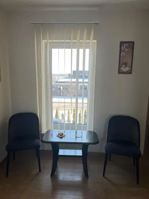 a table and two chairs in a room with a window at Pilaites svetingi namai in Vilnius
