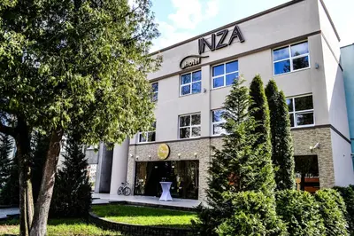 a large white building with a sign on it at Inza Guest House in Druskininkai
