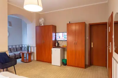 a room with wooden cabinets and a living room at Inza Guest House in Druskininkai