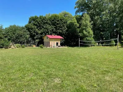 a house in the middle of a field with a net at Sveikatinimas kaime in Vilkaviškis