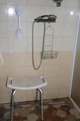 a shower in a bathroom with a bench in a room at Sveikatinimas kaime in Vilkaviškis