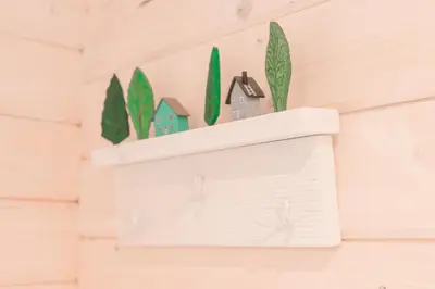 a shelf with houses and cacti on a wall at Gandro lizdas in Lekėčiai