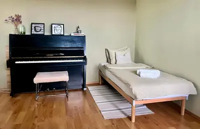 a piano in a room with a chair and a bench at Lakeview Retreat in Vievis in Vievis