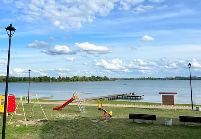 a park with playground equipment and a dock on the water at Lakeview Retreat in Vievis in Vievis