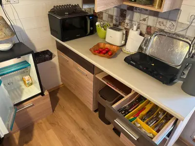 a kitchen with a counter top with a microwave at RYTO GARSAI in Merkinė