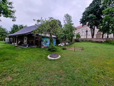 a house in a yard with a building at RYTO GARSAI in Merkinė