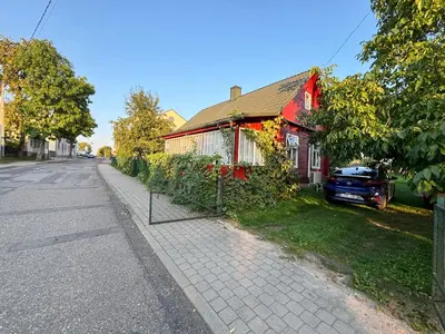 a house on the side of a street with a fence at RYTO GARSAI in Merkinė