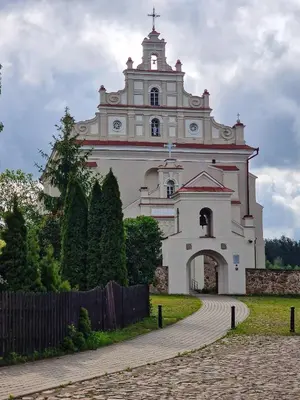 a large white building with a clock tower at RYTO GARSAI in Merkinė